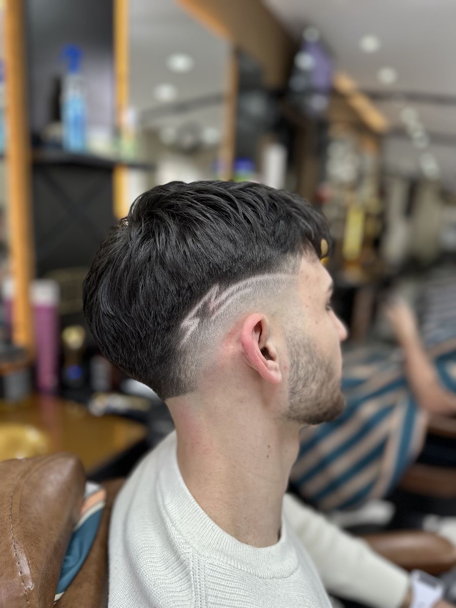 Textured fringe with skin fade and shaved line design at OTB's Barberhouse
