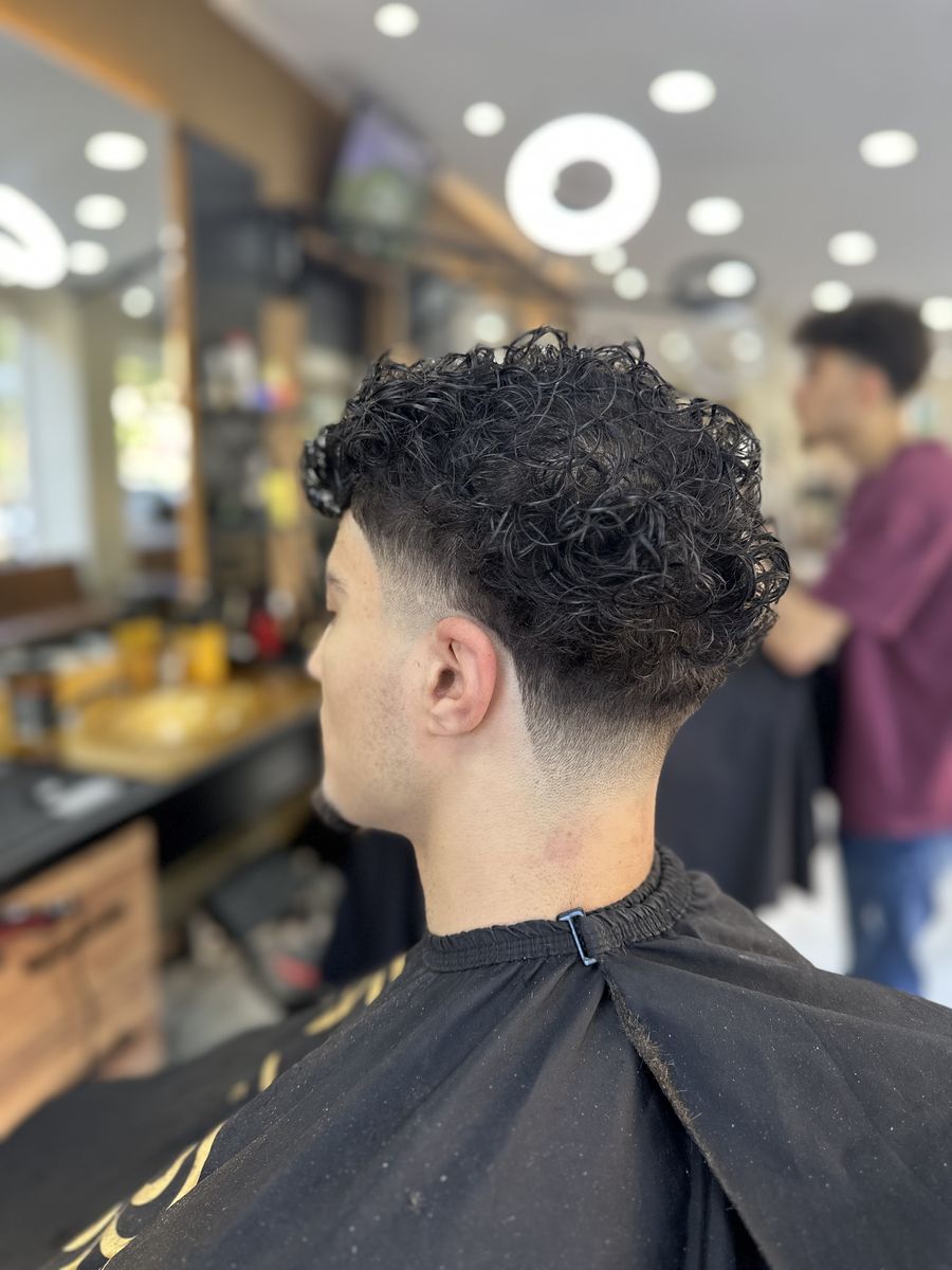 Curly hair with a low taper fade at OTB's Barberhouse