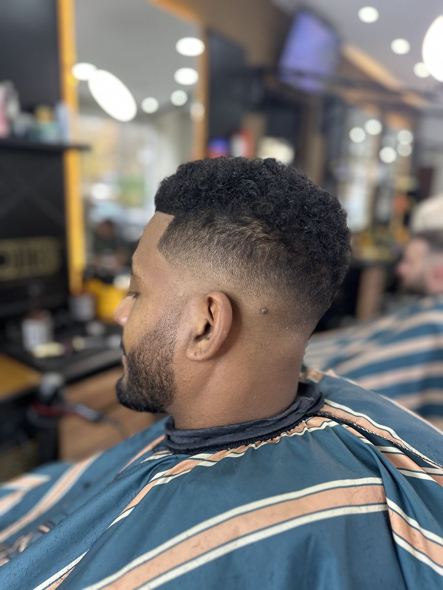 Afro hair with a fade and lined-up beard at OTB's Barberhouse